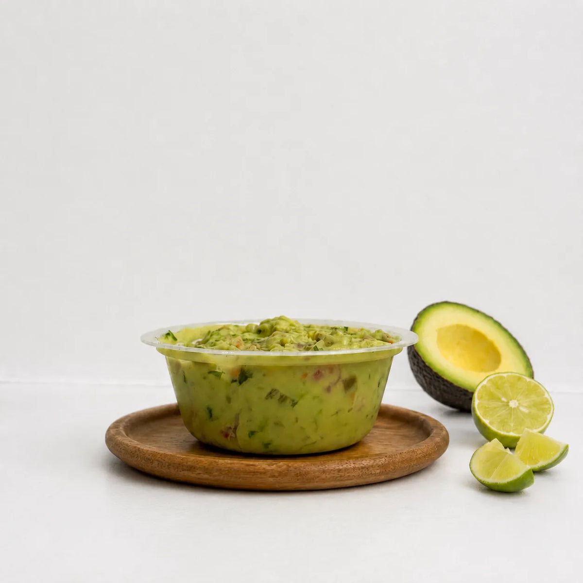 Open tub of The OG Guacamole on a wooden board
